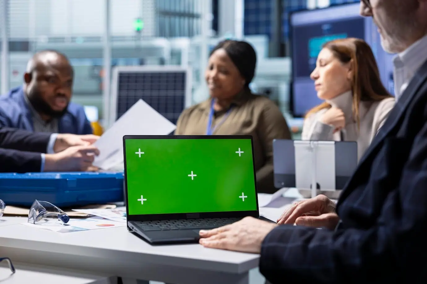 Инвесторы фабрики рассматривают документацию на макете ноутбука.