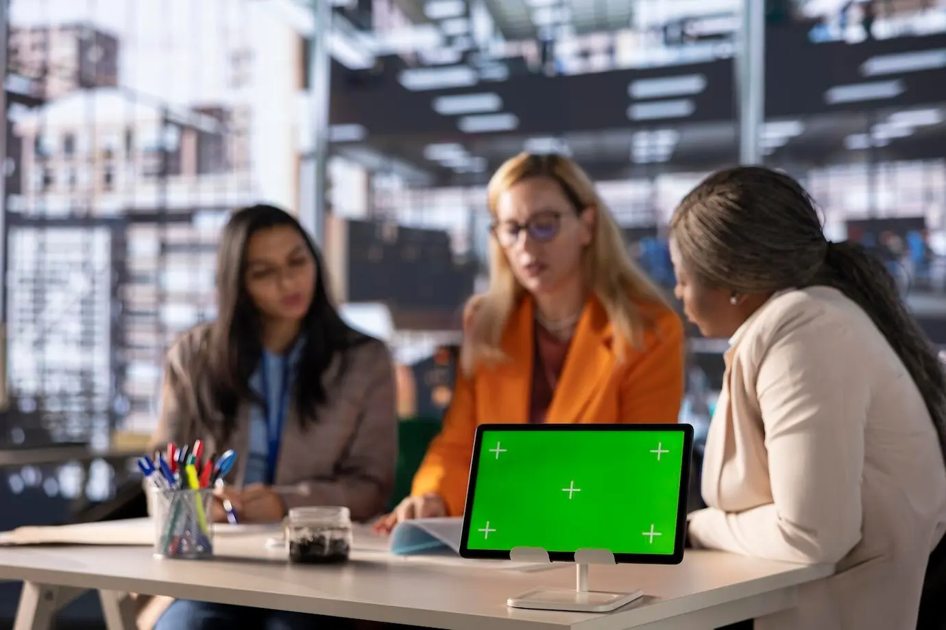Разнообразные деловые женщины занимаются стратегическим планированием в деловом офисе с зеленым экраном.