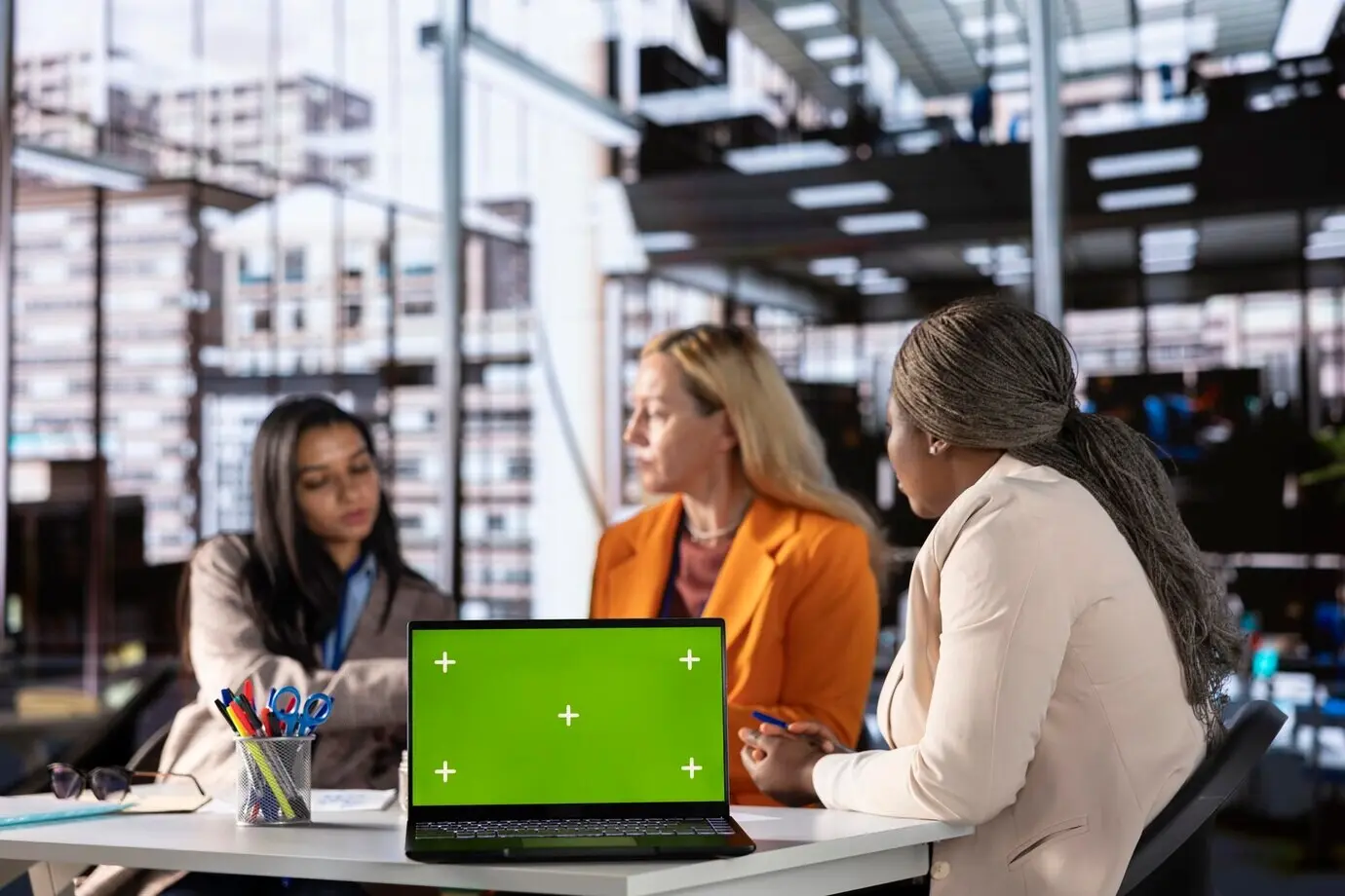 Разнообразная группа коллег-женщин, обеспечивающая достижение целей, рядом с хромакеем.