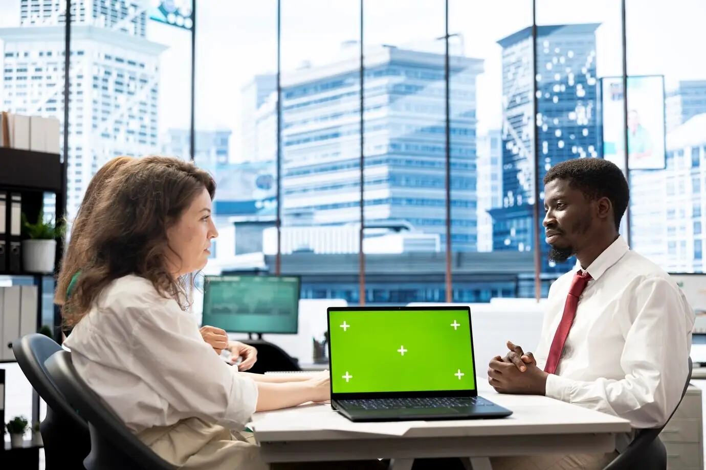 HR-эксперты ведут переговоры о предложениях о работе и зарплатных пакетах, используя ноутбук с зелёным экраном.