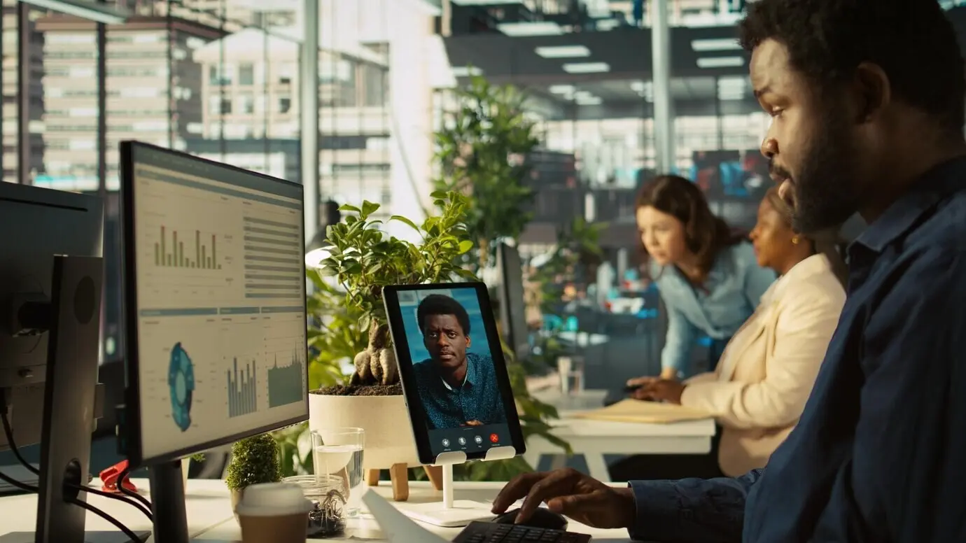 Сотрудник в офисе разговаривает с менеджером во время видеозвонка.